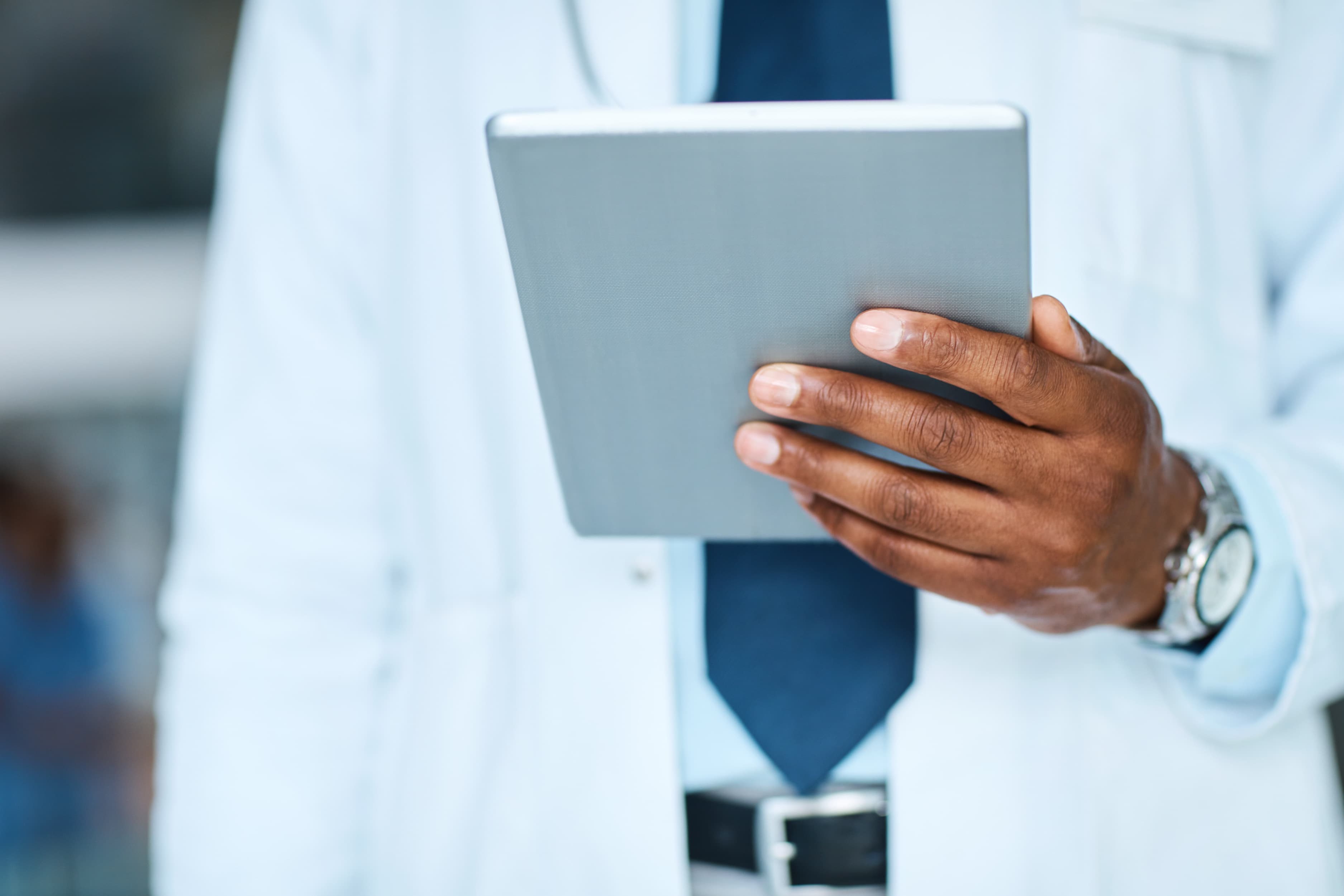 Praticien consultant un dossier sur tablette